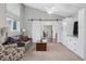 Open living room with a sliding barn door, hardwood and carpeted floors, and a view to the dining area at 7636 S Eaton Way, Littleton, CO 80128