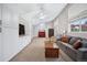 Spacious living room featuring a gray couch, coffee table, and a brick accent wall at 7636 S Eaton Way, Littleton, CO 80128