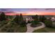 Charming two-story home with mature trees and a circular driveway at sunset at 5855 Saddle Creek Trl, Parker, CO 80134