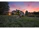 Stunning exterior view of a well-maintained home with professional landscaping under a gorgeous, colorful sunset at 5855 Saddle Creek Trl, Parker, CO 80134
