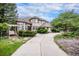 Stately home with a circular driveway, mature landscaping, and inviting porch swing at 5855 Saddle Creek Trl, Parker, CO 80134
