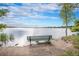 Lake view featuring a bench near the shoreline, offering a peaceful spot to relax and enjoy the serene scenery at 5855 Saddle Creek Trl, Parker, CO 80134