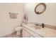 Charming powder bathroom with sleek fixtures, a vanity sink and a round mirror at 5938 E Weaver Cir, Centennial, CO 80111