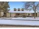 Inviting brick home showcasing a two-car garage and manicured landscaping covered in snow at 5938 E Weaver Cir, Centennial, CO 80111