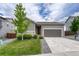 Beautiful gray home with a well-maintained lawn and a driveway leading to a two-car garage at 612 Blue Teal Dr, Castle Rock, CO 80104