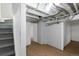 Unfinished basement area featuring painted floors, exposed beams, and access to storage at 3336 N Saint Paul St, Denver, CO 80205