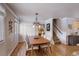 A dining room has a chandelier and a wood table with seating for six near the stairs at 7835 Nelson St, Arvada, CO 80005