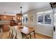 A dining room has a chandelier, a wood table with seating for six, and two windows at 7835 Nelson St, Arvada, CO 80005