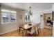 A dining room has a chandelier and a wood table with seating for six near the fireplace at 7835 Nelson St, Arvada, CO 80005