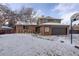 Two-story home with a brick and brown siding, attached garage, and snow-covered front yard at 7835 Nelson St, Arvada, CO 80005