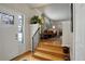 Inviting foyer with hardwood floors, stairs, and an open view to the living room with stylish decor at 7835 Nelson St, Arvada, CO 80005