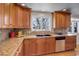 Kitchen featuring granite countertops, wood cabinets, and a stainless steel dishwasher and sink at 7835 Nelson St, Arvada, CO 80005