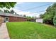 Spacious backyard with green grass, shed, patio and exterior of the brick home at 6765 W 33Rd Ave, Wheat Ridge, CO 80033