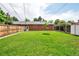 Large backyard featuring green grass, a storage shed, patio cover and brick home exterior at 6765 W 33Rd Ave, Wheat Ridge, CO 80033