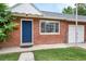 Brick home exterior with a vibrant blue front door, attached garage, window and green lawn at 6765 W 33Rd Ave, Wheat Ridge, CO 80033