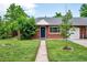 Charming brick home with a well-manicured front yard, sidewalk and mature trees at 6765 W 33Rd Ave, Wheat Ridge, CO 80033