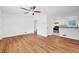 Bright living room featuring hardwood floors, a ceiling fan, and open access to the kitchen at 6765 W 33Rd Ave, Wheat Ridge, CO 80033