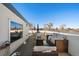 Relaxing rooftop deck features wicker furniture and city views at 2726 Federal Blvd # 1, Denver, CO 80211