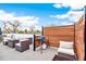 Outdoor rooftop deck with a grill, wood privacy fence, comfortable seating, and sunny skies above at 2726 Federal Blvd # 1, Denver, CO 80211