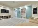 Finished basement with gray carpeting, decorative artwork, entertainment center, and comfortable seating at 7472 S Utica St, Littleton, CO 80128