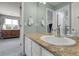 Bathroom with a large vanity mirror, granite countertops, white cabinets, and access to the bedroom and shower at 7472 S Utica St, Littleton, CO 80128