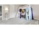 Bedroom features gray carpet and a lofted bed with a ladder, colorful decorations, and a connected desk at 7472 S Utica St, Littleton, CO 80128