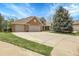 Charming home with a three-car garage, landscaped yard, and basketball hoop on the driveway at 7472 S Utica St, Littleton, CO 80128