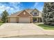 Charming two-story home featuring a brick facade, three-car garage, and a well-manicured front lawn at 7472 S Utica St, Littleton, CO 80128