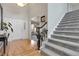 Inviting foyer with gleaming hardwood floors, a grand staircase, and elegant front doors at 7472 S Utica St, Littleton, CO 80128