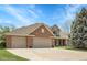 Lovely brick home featuring a three-car garage, well-maintained landscaping and traditional design at 7472 S Utica St, Littleton, CO 80128