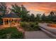 Relaxing gazebo with hanging flowers, alongside a stone fire pit and lush landscaping at 7472 S Utica St, Littleton, CO 80128