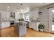 Well-lit kitchen boasting a center island, white cabinets, and stainless steel appliances at 7472 S Utica St, Littleton, CO 80128