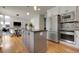 Open kitchen with a large island, stainless appliances, and seamless view into dining space at 7472 S Utica St, Littleton, CO 80128