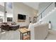 Bright living room featuring vaulted ceilings, plush seating, and a modern entertainment center at 7472 S Utica St, Littleton, CO 80128