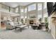 Spacious living room featuring a cozy fireplace, soaring ceilings, and abundant natural light at 7472 S Utica St, Littleton, CO 80128