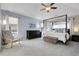 Light-filled main bedroom featuring a four-poster bed, sitting area, and soft carpeting at 7472 S Utica St, Littleton, CO 80128