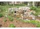 Rock feature with pond and surrounding landscaping, offering a relaxing outdoor view at 7472 S Utica St, Littleton, CO 80128