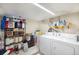 Functional basement laundry area with washer, dryer, and ample storage shelves for supplies at 11940 W Independence Ave, Lakewood, CO 80401