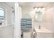 Modern bathroom with tiled shower, vanity, and convenient storage shelves, perfect for organization at 11940 W Independence Ave, Lakewood, CO 80401