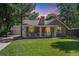 Charming brick home with a lush front lawn and a welcoming porch, perfect for relaxing outdoors at 11940 W Independence Ave, Lakewood, CO 80401