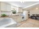 Bright kitchen featuring white cabinetry, tile flooring, and adjacent dining area for easy meals at 11940 W Independence Ave, Lakewood, CO 80401