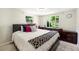 Cozy main bedroom with plush bedding, natural light, and a view of the well-maintained backyard at 11940 W Independence Ave, Lakewood, CO 80401