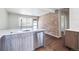 Open kitchen featuring stainless steel appliances, island with sink, and access to living area at 4233 Shoshone St, Denver, CO 80211