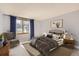 Comfortable bedroom with a cozy chair, warm carpet, and natural light at 8159 Lodgepole Trl, Lone Tree, CO 80124