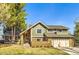 Inviting two-story home with a brick and siding facade, complemented by a well-manicured lawn and mature trees at 8159 Lodgepole Trl, Lone Tree, CO 80124