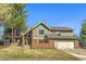 Charming two-story home featuring a brick and green wood facade, attached garage, and well-manicured lawn at 8159 Lodgepole Trl, Lone Tree, CO 80124