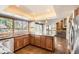 Kitchen with wooden cabinets, granite counters, large windows, and an island at 8159 Lodgepole Trl, Lone Tree, CO 80124