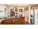 Open concept kitchen featuring a granite countertop island, wood cabinetry, and stainless steel appliances at 8159 Lodgepole Trl, Lone Tree, CO 80124
