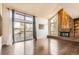 Bright living room with a brick fireplace, large windows, and sliding door access to the deck with hardwood floors at 8159 Lodgepole Trl, Lone Tree, CO 80124