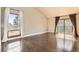 Bright living room featuring hardwood floors, and sliding glass doors with curtains leading to the outside at 8159 Lodgepole Trl, Lone Tree, CO 80124